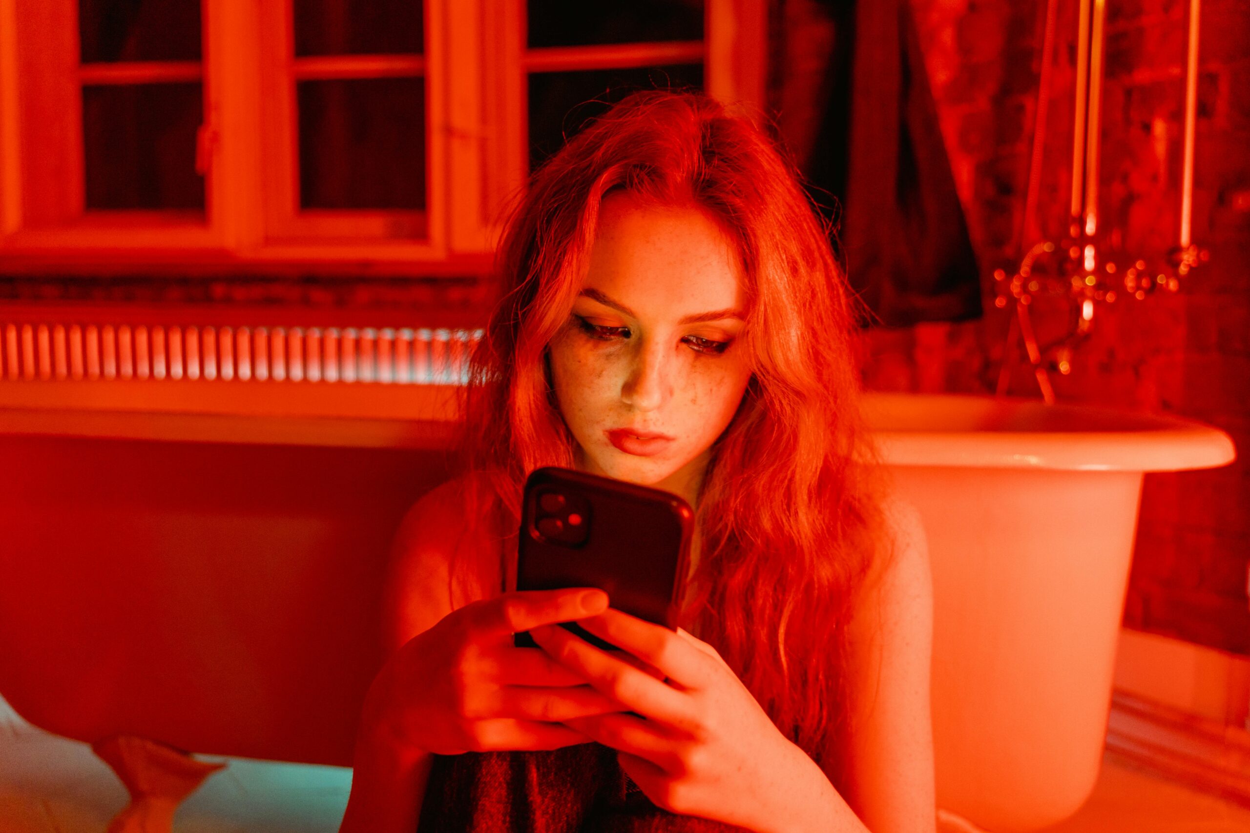 A tired person staring at a phone screen with a foggy or overwhelmed expression, symbolizing mental fatigue after social media use.